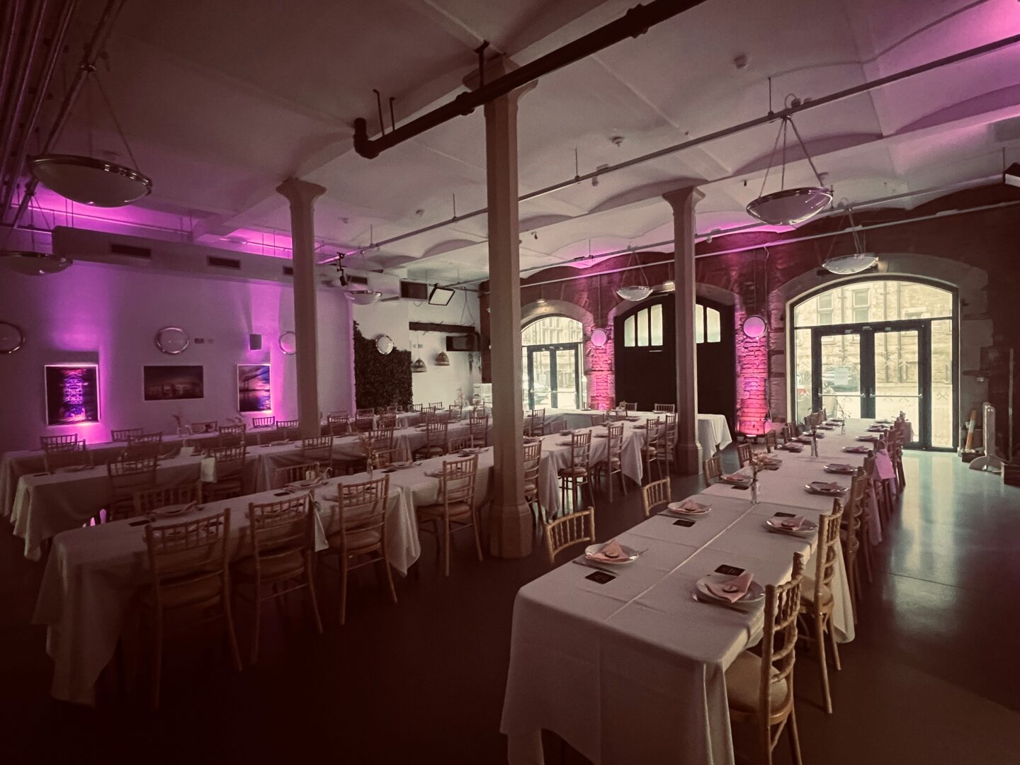 Old Fire Station dressed up for a wedding with long tables, chairs and purple lighting effects